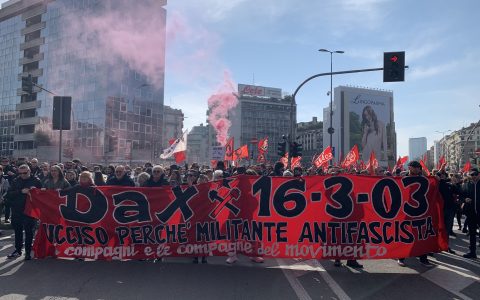 Alt Manifestanti dietro a uno striscione durante il corteo per Dax del 18 marzo, prima della partenza, in piazzale Loreto