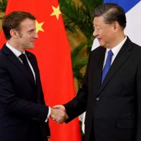 Il Presidente francese Emmanuel Macron stringe la mano al suo omologo cinese Xi Jinping, durante la sua visita a Pechino