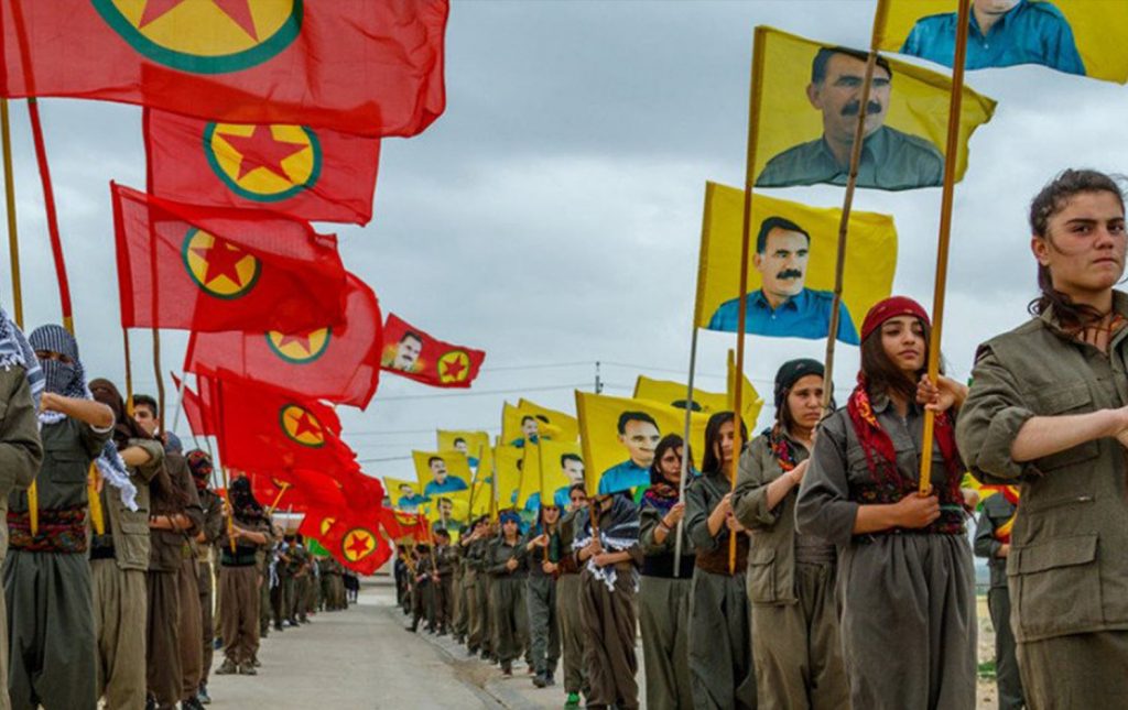 Una schiera di combattenti del Pkk. Sulle bandiere il simbolo dell'organizzazione e il volto del fondatore, Abdullah Ocalan