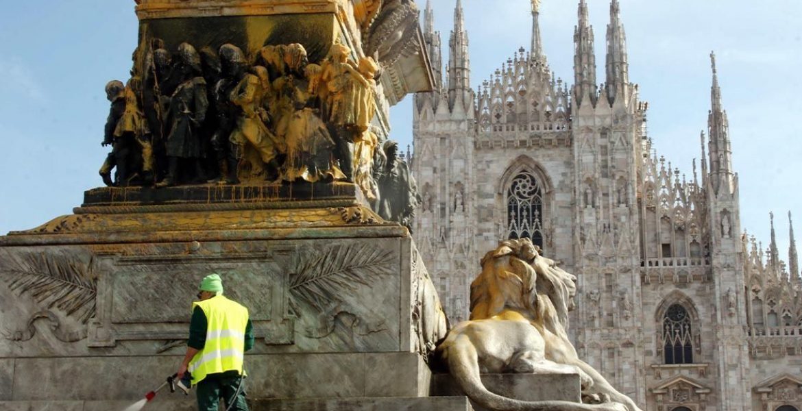 Un addetto dell'Amsa cerca di ripulire la statua di Vittorio Emanuele II imbrattata dagli attivisti di Ultima Generazione