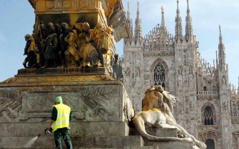 Un addetto dell'Amsa cerca di ripulire la statua di Vittorio Emanuele II imbrattata dagli attivisti di Ultima Generazione