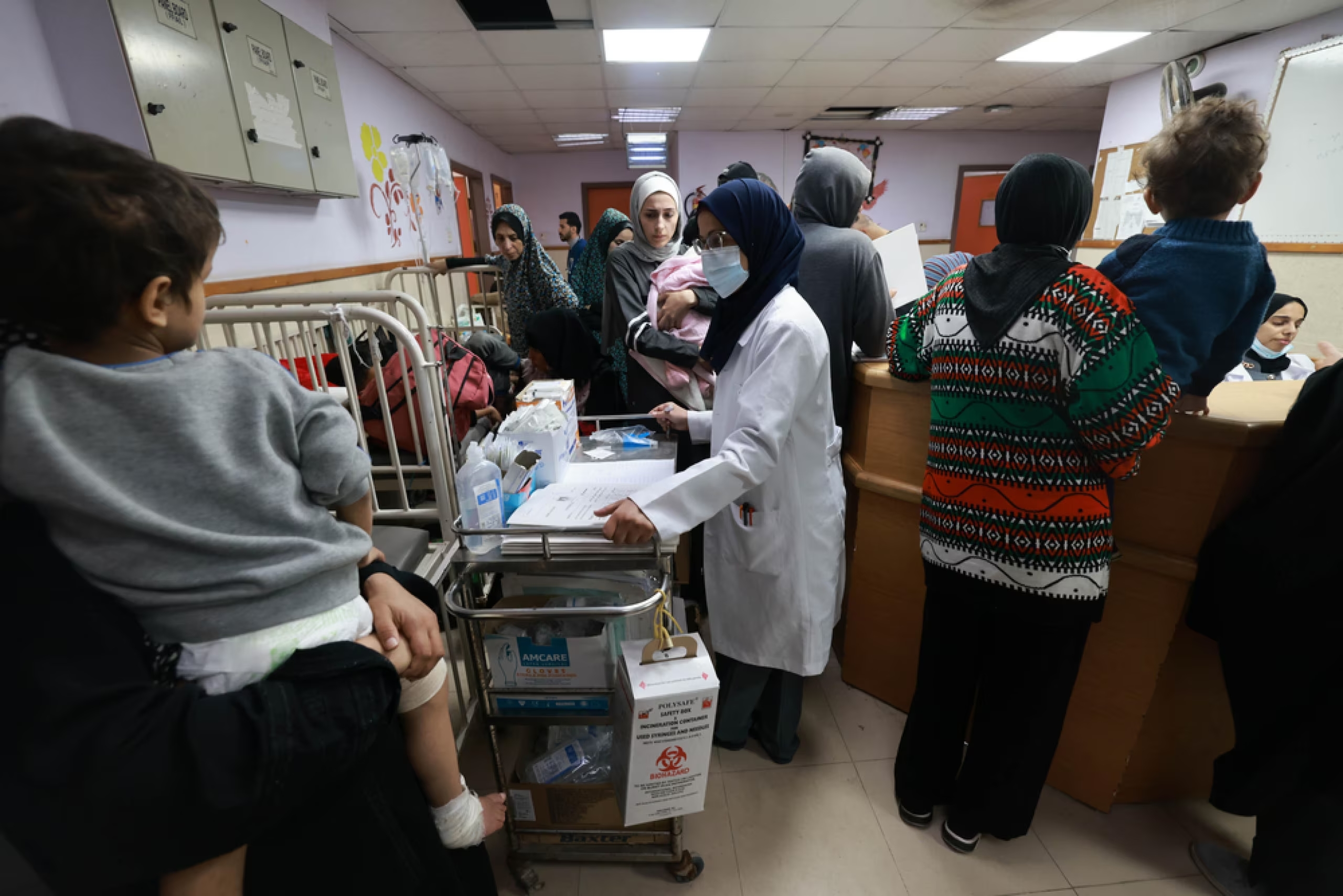 Alcuni bambini sfollati da Gaza in un ospedale, accompagnati dalle famiglie.