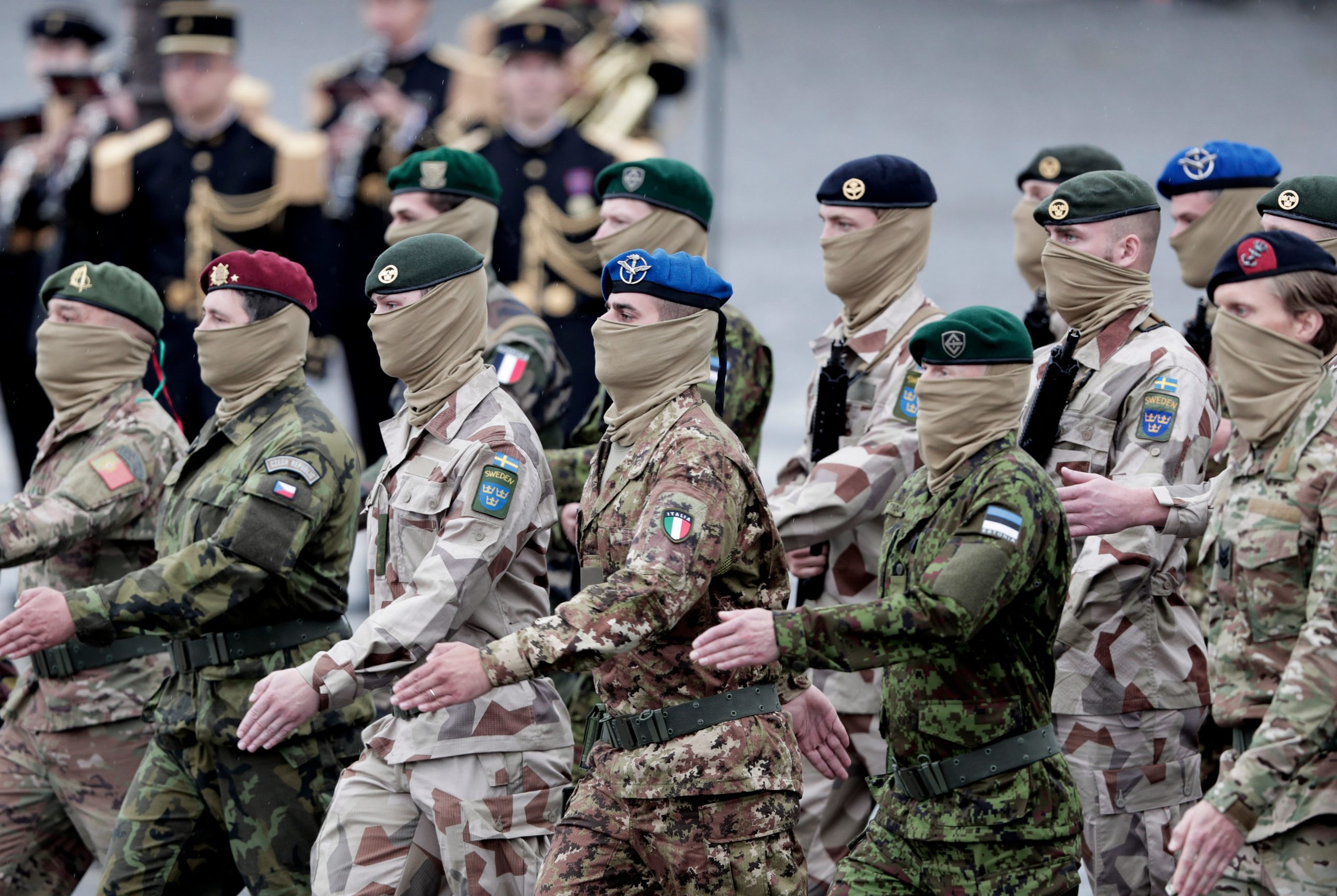 Basta una foto come questa per comprendere quanto la Difesa dell'UE sia diversificata tra Stato e Stato. Personale militare europeo sfila durante una parata, ognuno con la propria mimetica nazionale.