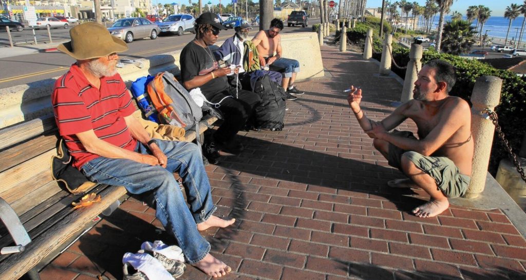 Senzatetto seduti su una panchina a San Diego, lungo le rive dell'Oceano Pacifico
