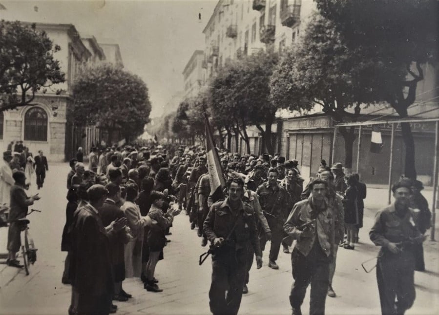 Le squadre partigiane sfilano nel centro di Savona il 25 aprile 1945, il giorno dopo la liberazione della città.